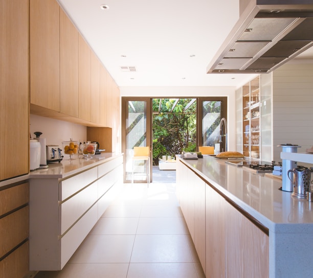 white wooden kitchen island and cupboard cabinets near glass panel door