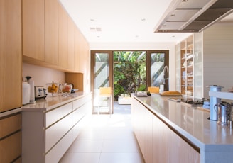 white wooden kitchen island and cupboard cabinets near glass panel door