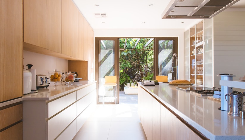 white wooden kitchen island and cupboard cabinets near glass panel door