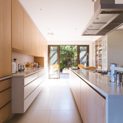 white wooden kitchen island and cupboard cabinets near glass panel door