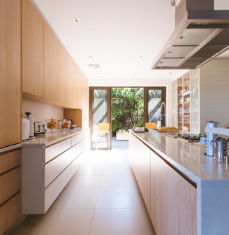 white wooden kitchen island and cupboard cabinets near glass panel door