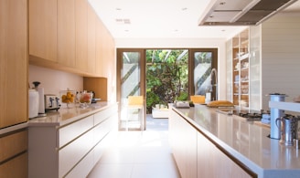 white wooden kitchen island and cupboard cabinets near glass panel door