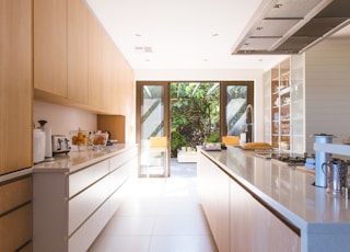 white wooden kitchen island and cupboard cabinets near glass panel door