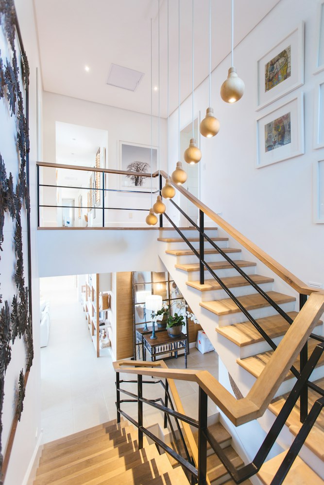 Bright interior stairwell with a pale wooden staircase and metal balustrade