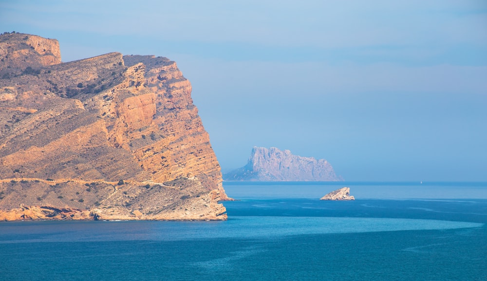 aerial photography of sea near mountain at daytime