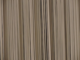 A pattern of vertical lines with varying thickness and shades, creating a barcode-like appearance.