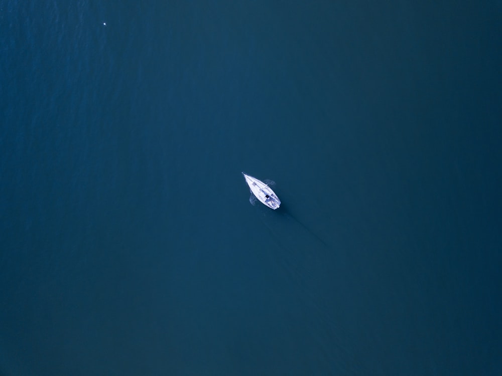 Photographie aérienne d’un bateau blanc sur un plan d’eau