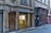 A narrow old street features stone buildings with a sign indicating the Vieux Lyon Cathedral-St Jean metro station entrance. The architecture includes rough stonework and mixed material facades with street signs and a heavy wooden door adorned with a metal knocker.