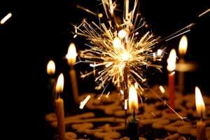 close up photography of sparkler beside candles