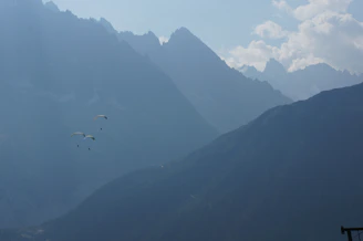 Couple enjoying a combined paragliding and cycling adventure in scenic mountains.