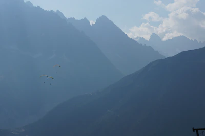 Couple enjoying a combined paragliding and cycling adventure in scenic mountains.