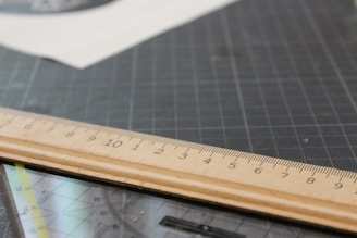 Close-up of a stainless steel cork back ruler resting on a wooden workbench with soft natural light.