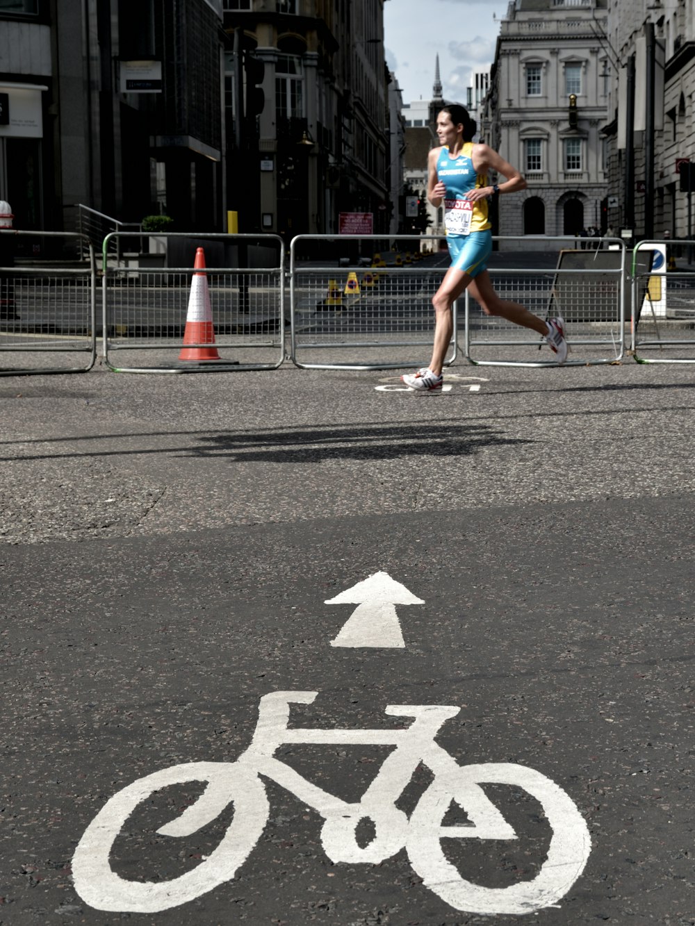 woman running on gray concrete pavement taken at daytime