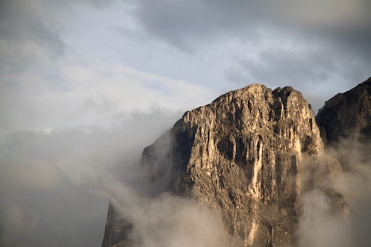photo of gray rock formation covered in cloud in Lungiarü Italy