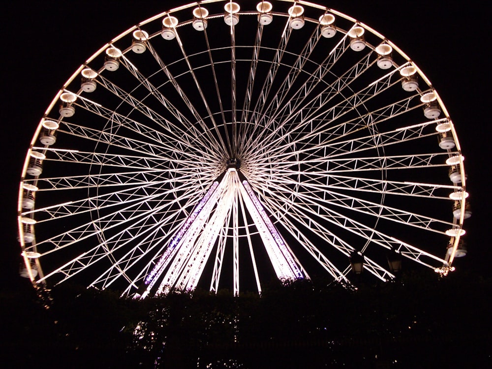 Photo d’une grande roue éclairée pendant la nuit