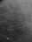 Surface with a grainy texture, possibly asphalt or a similar material.