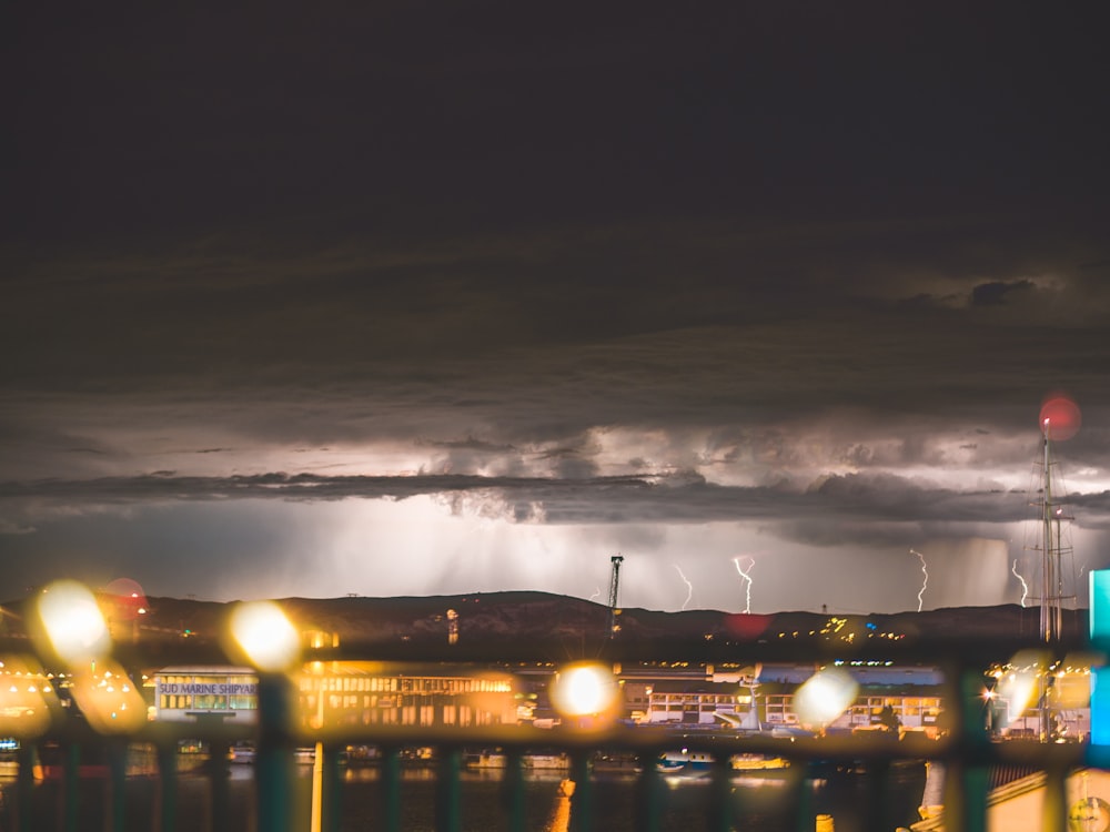 buildings in distant of mountain with lightning