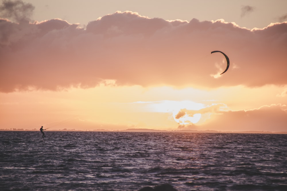 person in water ski on body of water during sunset