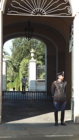 A vigilant Indian security guard monitoring the entrance of an educational institution.