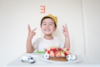 boy in front of cake and white car toy