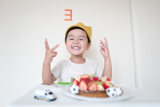 boy in front of cake and white car toy