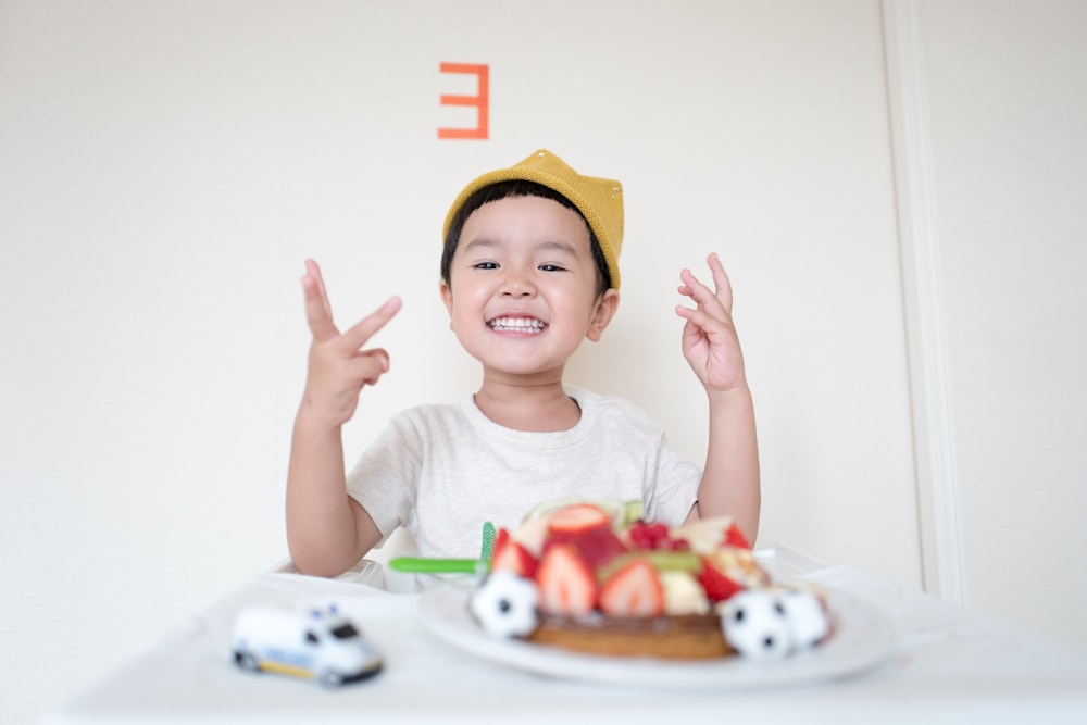 boy in front of cake and white car toy