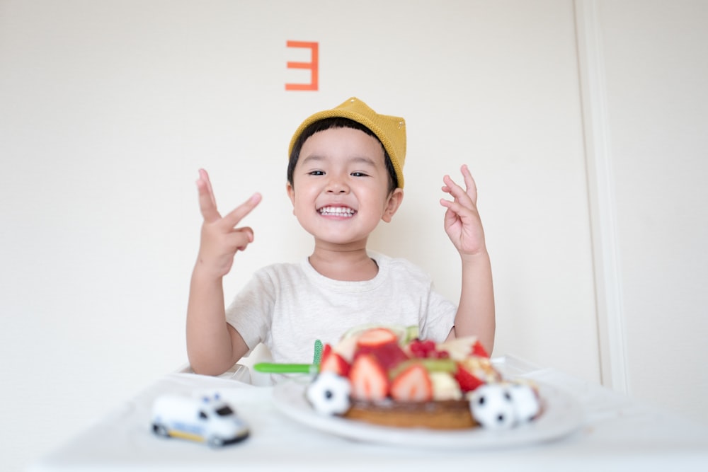 ケーキと白い車のおもちゃの前の男の子