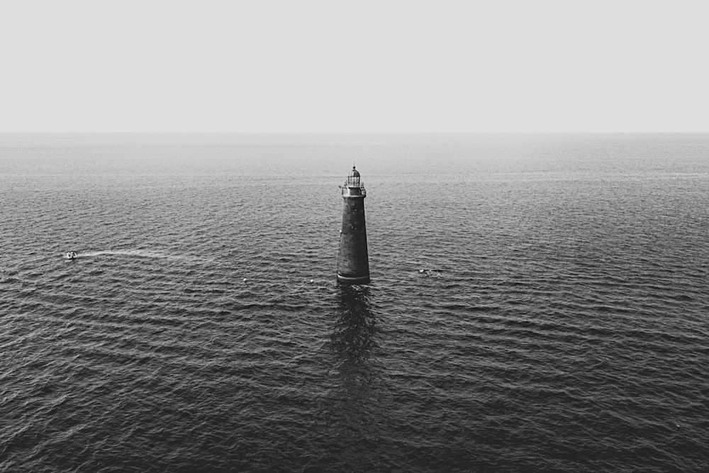 gray concrete lighthouse surrounded by ocean water