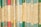 A close-up of a row of vintage paperback books with various titles on their spines. The books are arranged vertically, showing a variety of colors and fonts, giving a nostalgic and scholarly atmosphere.
