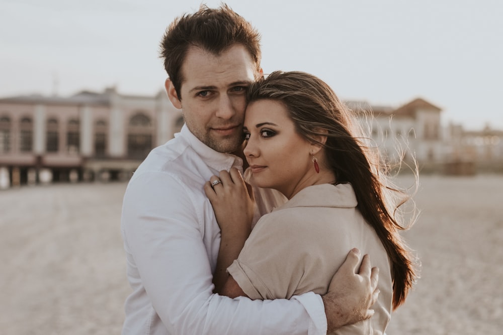 man hugging woman during daytime