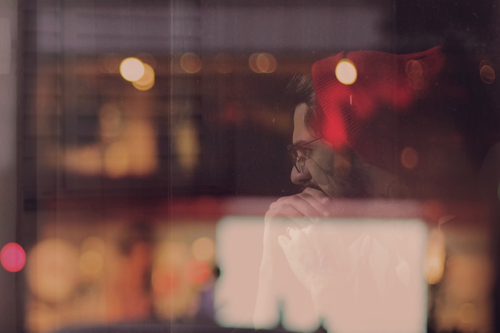 a man in a red hat looking out a window