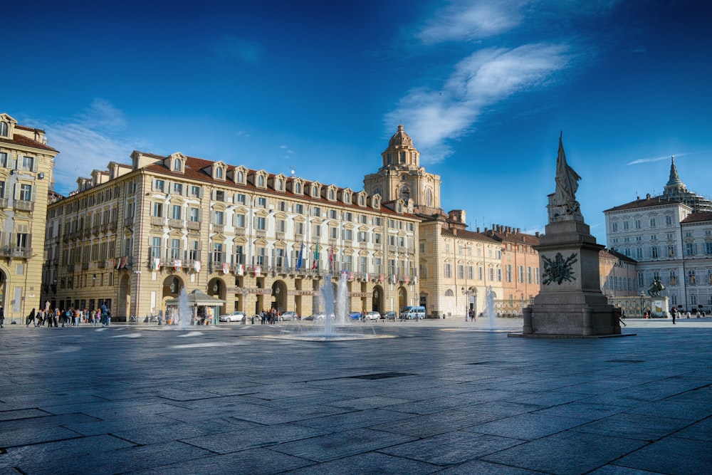 beigefarbener Betonpalast mit Statue davor unter blauem Himmel bei Tag