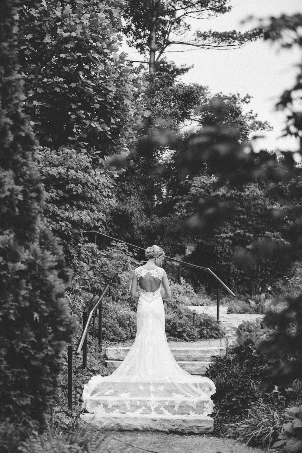 Mujer en vestido de novia blanco caminando en escalera de hormigón gris