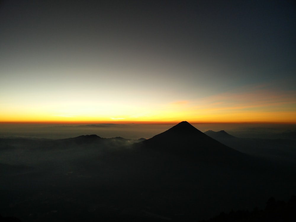 aerial photography of mountain surrounded by white clouds