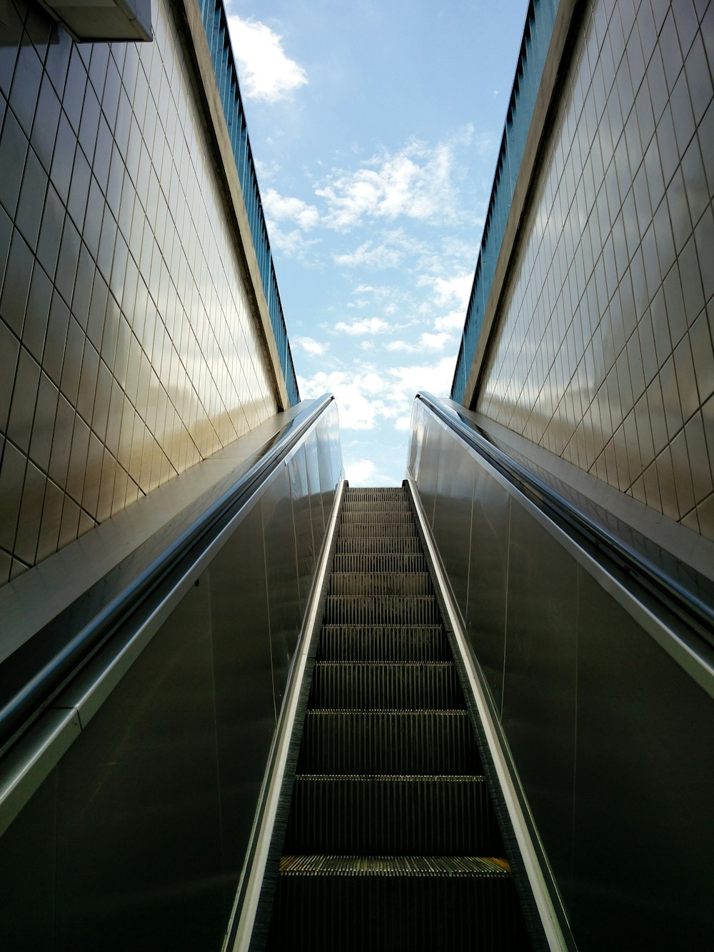 Escalera mecánica en medio de paredes de azulejos