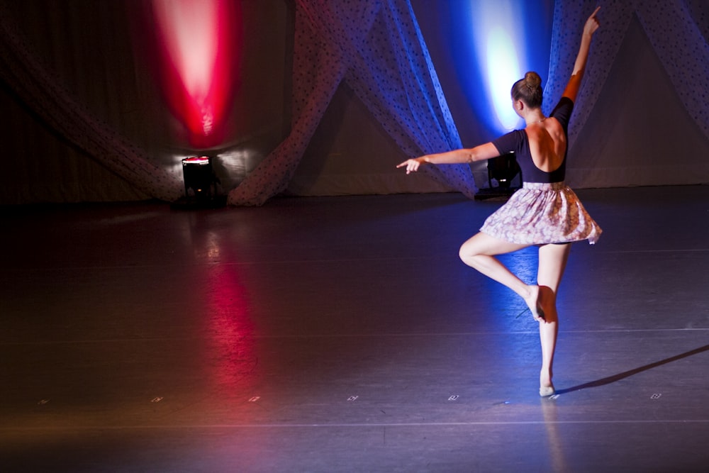 ballerine sur scène avec projecteurs rouges et bleus