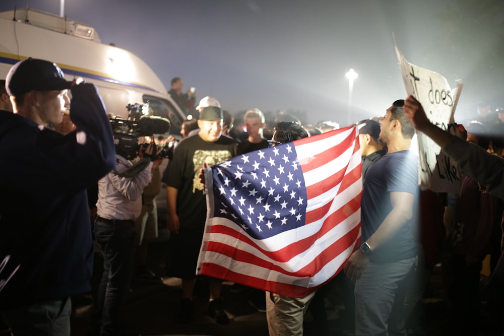 hombre sosteniendo la bandera estadounidense