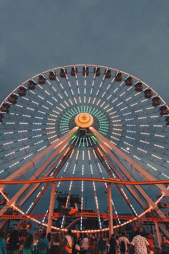 people in front of ferris wheel under gray sky in Wildwood United States