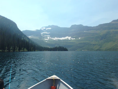 A serene Swedish lake surrounded by pine trees with a small boat ready for bass fishing.