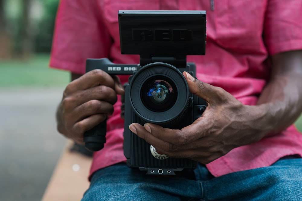 person holding black DSLR camera