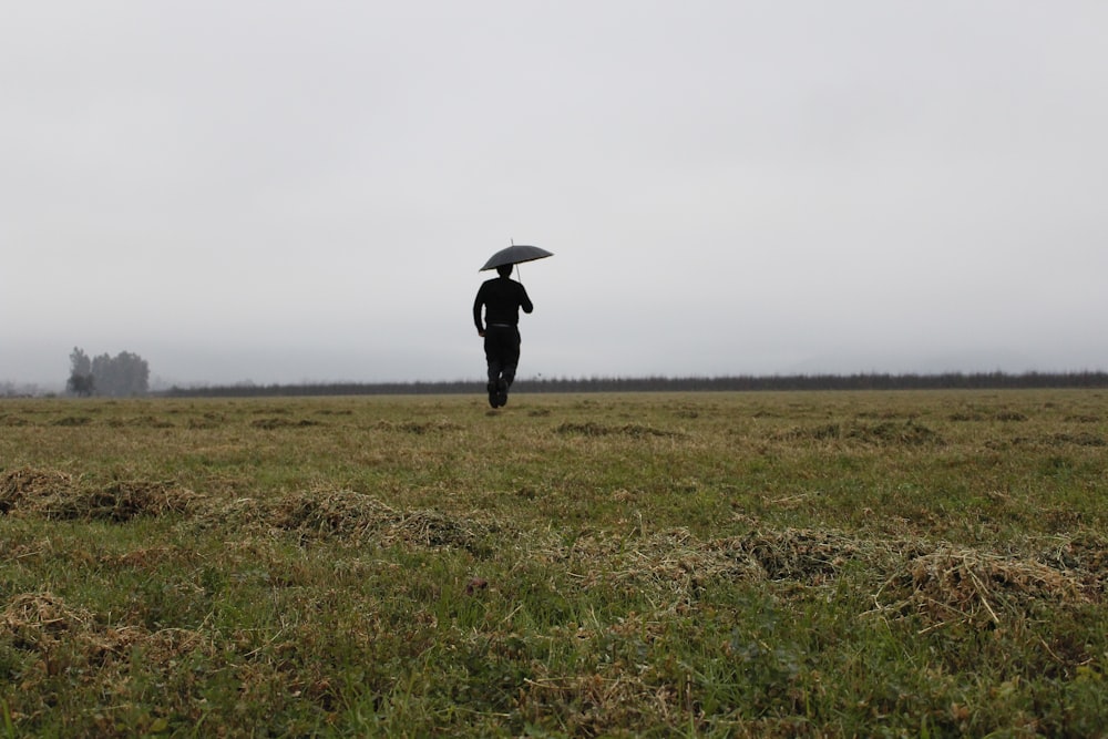 man walking on grass plain