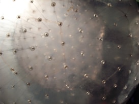 A close-up view of a transparent inflatable sphere, showing its textured surface with circular connectors and faint internal structure.