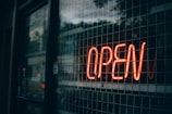 A close-up shot of a glow sign board lit up at night, illuminating a storefront warmly.