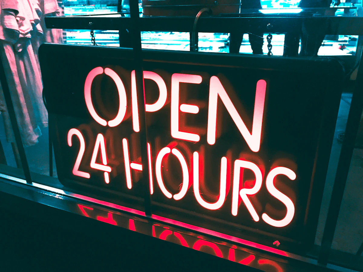 Open 24 hours neon sign glowing in a dark window