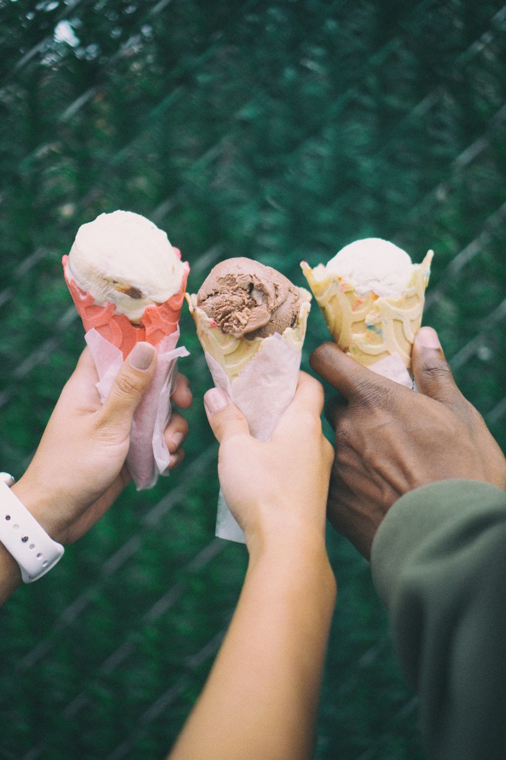 Tres personas sosteniendo conos de helado en sus manos