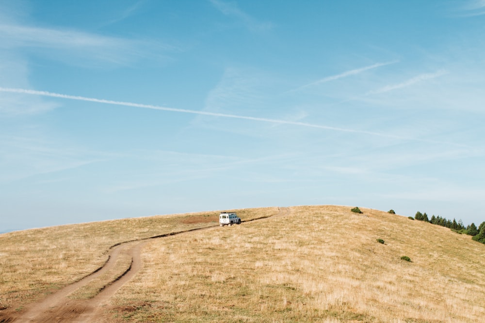 white vehicle on brown hill