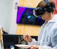 man wearing black virtual reality headset while painting near brown wall by Billetto Editorial (https://unsplash.com/@billetto)