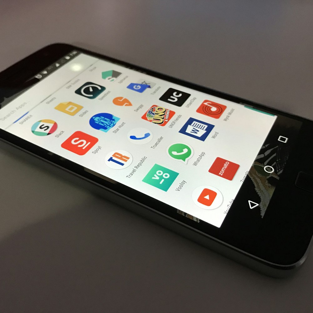 schwarzes Android-Smartphone auf grauer Fläche liegend