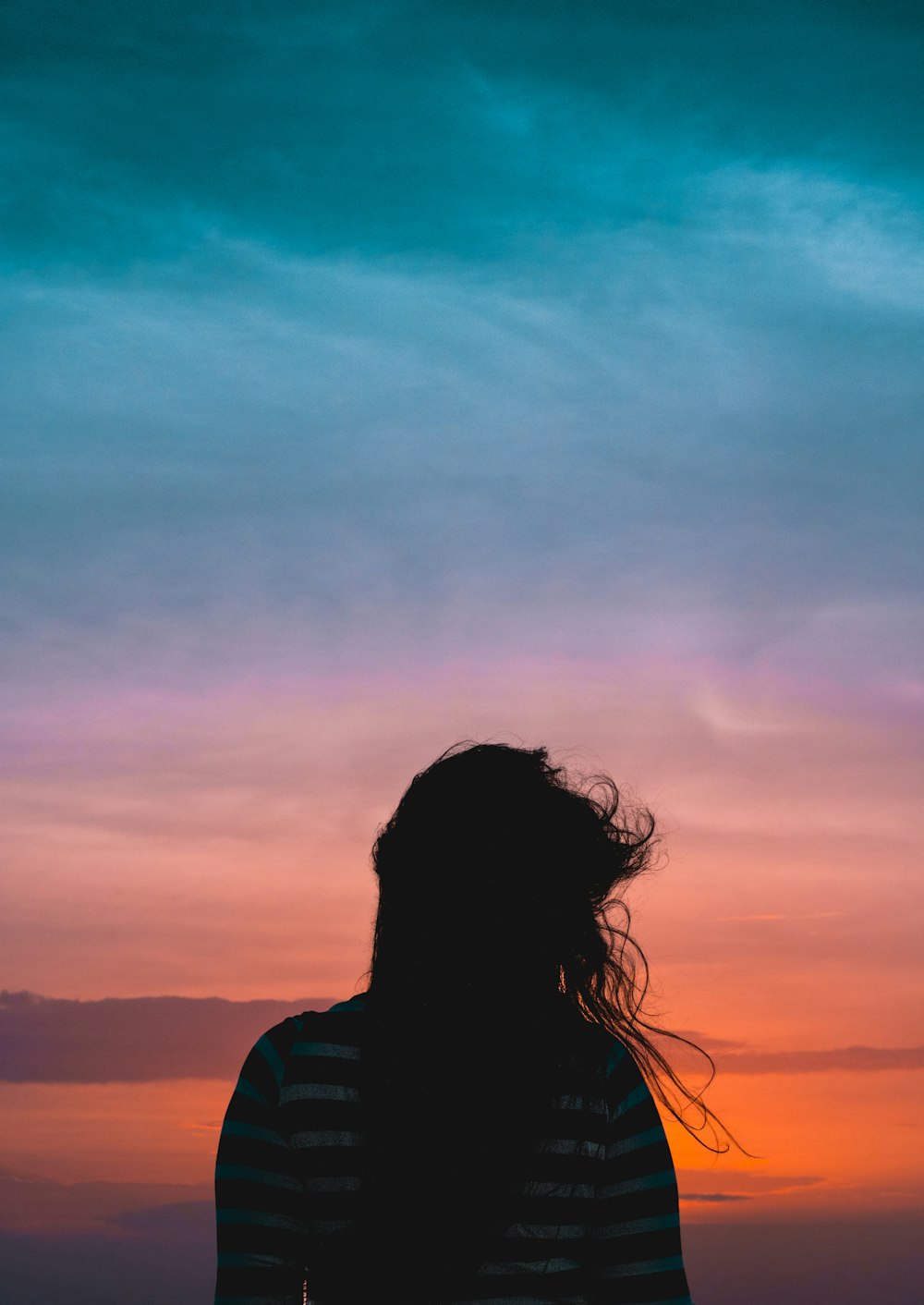 femme portant rayé debout sous ciel nuageux