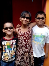 A happy family with children wearing colorful glasses outdoors on a sunny day.
